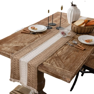 Rustic linen table runner with fringes and beige stripes on a wooden dining table