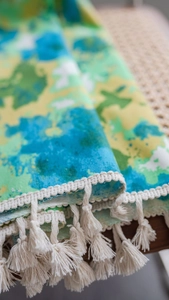 Détail d'un rideau à motif floral vert aquarelle avec d'élégantes franges blanches