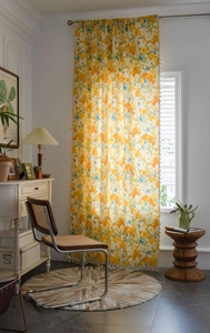 Close-up of vintage yellow floral print curtain with elegant beige tassel fringe detail