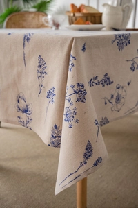 Close-up of linen tablecloth featuring blue botanical patterns and natural texture