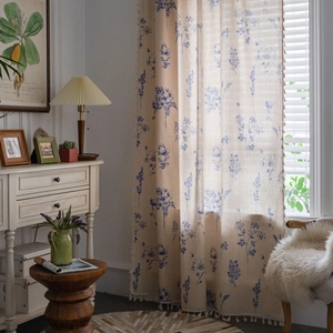 Pastoral blue floral print curtain with tassels in a cozy vintage kitchen setting