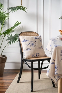 Close-up of linen tablecloth and pillow featuring blue floral patterns in rustic style