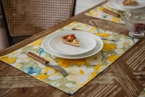 Detailed macro view of yellow floral print fabric runner on a rustic wooden table surface