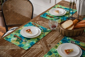 Macro detail of tie-dye green camouflage cotton linen placemat on a wooden dining table