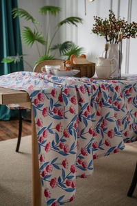 Detailed texture of floral linen tablecloth with pink blossoms on a wooden table