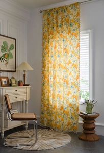 Close-up of yellow floral cotton linen curtain with elegant beige tassel fringe detailing
