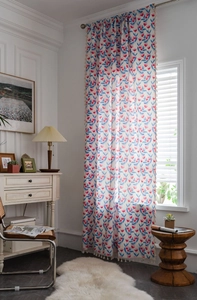 Detail eines Vorhangs im Boho-Stil mit Blumenmuster und beigen handgemachten Quasten