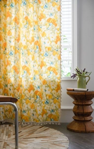 Detail view of floral print curtain with delicate cream pompom fringe and soft flower patterns