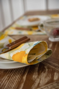 Close-up of yellow floral cotton linen table runner with detailed stitching on fabric