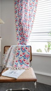 Detail eines böhmischen Stoffes mit roten Tulpen, blauen Blättern und cremefarbenen Quasten
