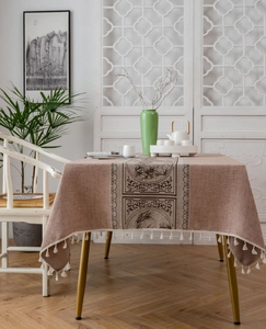 Detail of brown linen table runner with traditional bamboo patterns and fringe tassels