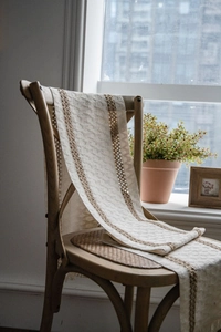 Close-up of cotton linen table runner with woven brown stripes and fringe details