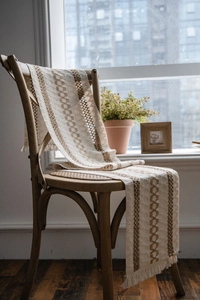 Close-up of woven cotton linen table runner with geometric patterns and fringe