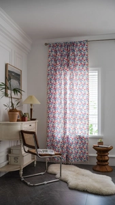 Detail eines Vorhangs im Boho-Stil mit roten Tulpen und eleganten beigen Quastenfransen