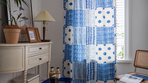 Details des blauen Vorhangs mit geometrischem Patchwork und Quasten im Boho-Stil