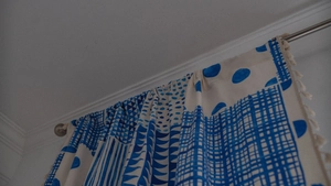 Detailansicht der blauen geometrischen Vorhänge mit Fransen und Metallringen