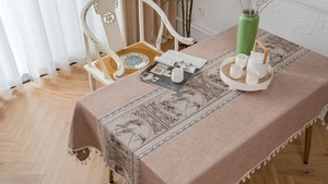 Detailed view of coffee linen table cloth with Chinese landscape print and white tassels