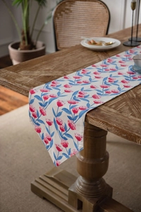 Detailed close-up of a pink floral table runner on a vintage dark wood grain table surface