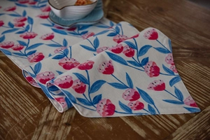 Macro detail of pink floral print on linen table runner with clean hemmed edges