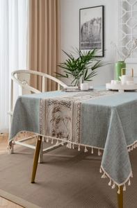 Detail of light blue linen tablecloth with traditional Chinese brocade and tassel trim