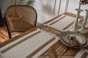 Detail of woven cotton linen placemat with brown stripes and decorative fringe edges