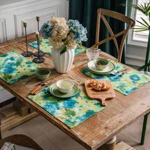 Set of four cotton linen table mats featuring artistic green tie-dye camo patterns