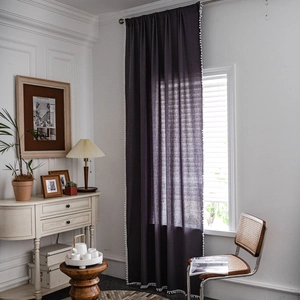 Deep purple linen-textured curtain with white pom-pom trim for a rustic home decor look