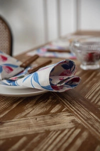 Detailed texture of cotton table runner with pink floral print on a rustic wooden table