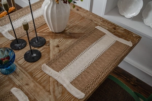 Detailed close-up of retro jute placemat featuring white lace trim on a wooden table