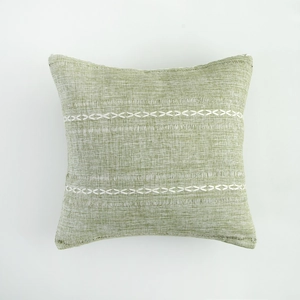 Detailed close-up of light green stripe embroidery on a textured linen cushion cover