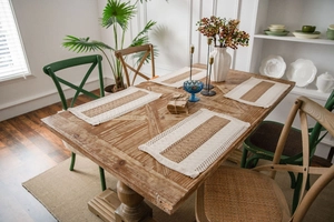 Close-up of rectangle woven placemats with fringe edge on a vintage wooden dining table