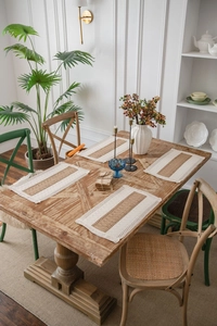 Detailed view of hand-woven rectangular placemats with fringe edge on a wood table