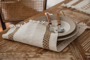 Close-up of bohemian woven table runner with tassel details on a vintage wooden table