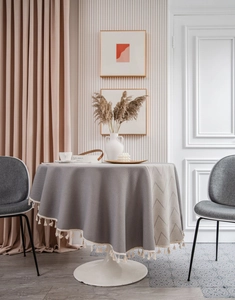 Detail of grey and beige geometric tablecloth featuring decorative cream tassels