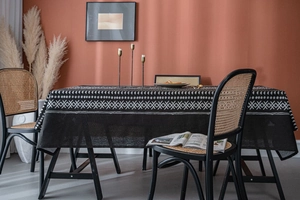 Detailed close-up of bohemian black tablecloth with white geometric patterns in a cozy dining room