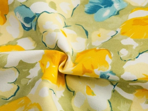 Macro view of floral print cushion cover fabric with yellow and white flowers