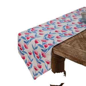 Pink tulip floral print table runner on wooden surface with elegant draping