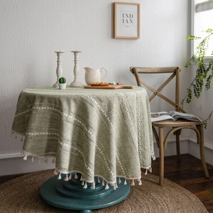 Nappe ronde verte en lin de coton avec motif tissé et pompons élégants en crème