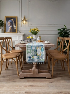 Detailed view of jacquard table runner with green fish pattern and fringe tassel beads