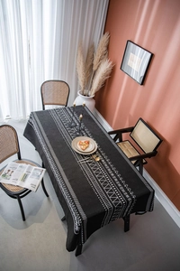 Detailed shot of black bohemian tablecloth featuring white geometric patterns and thick texture