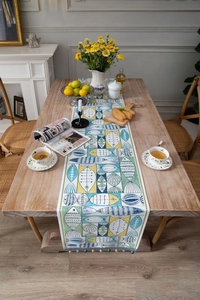 Close-up of Nordic jacquard table runner with fish pattern and blue pompom tassels