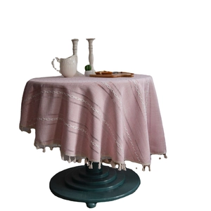 Nappe ronde rose avec broderie blanche, glands décoratifs et texture en coton et lin