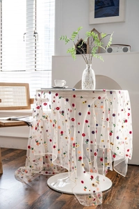 Detailed embroidery on white mesh lace tablecloth with colorful floral patterns