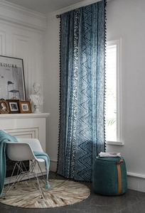 Detail of blue and white bohemian geometric curtain fabric with black tassel fringe trim