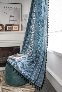 Detail view of blue bohemian geometric print curtain with stylish black tassel fringe