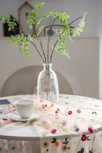 Detailed macro view of colorful floral embroidery patterns on white tulle lace fabric