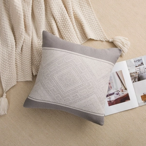 Detail of grey and beige geometric knit throw pillow with woven rhombic pattern texture