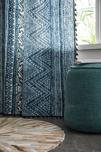 Detail of bohemian blue geometric print curtain with stylish black tassel fringe trim