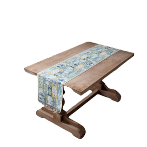 Green jacquard table runner featuring colorful fish patterns and dark blue tassels