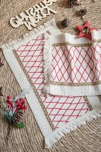 Detail of woven Christmas placemat with red diamond embroidery and soft fringe edges